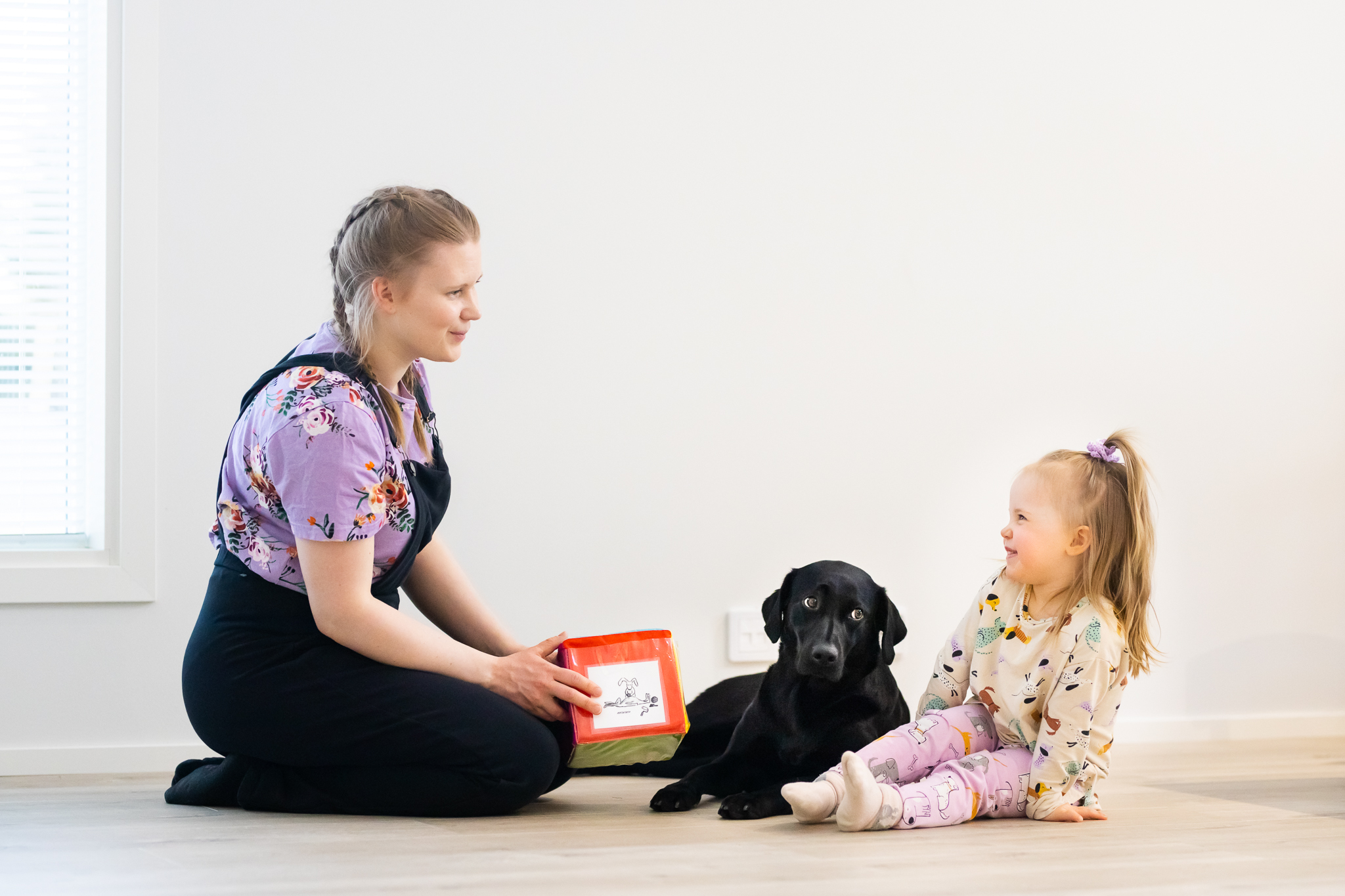Toimintaterapeutti työskentelemässä koira-avusteisesti lapsen kanssa