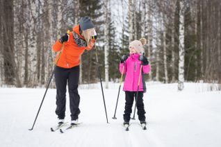 Fysioterapeutti harjoittelemassa hiihtoa lapsen kanssa